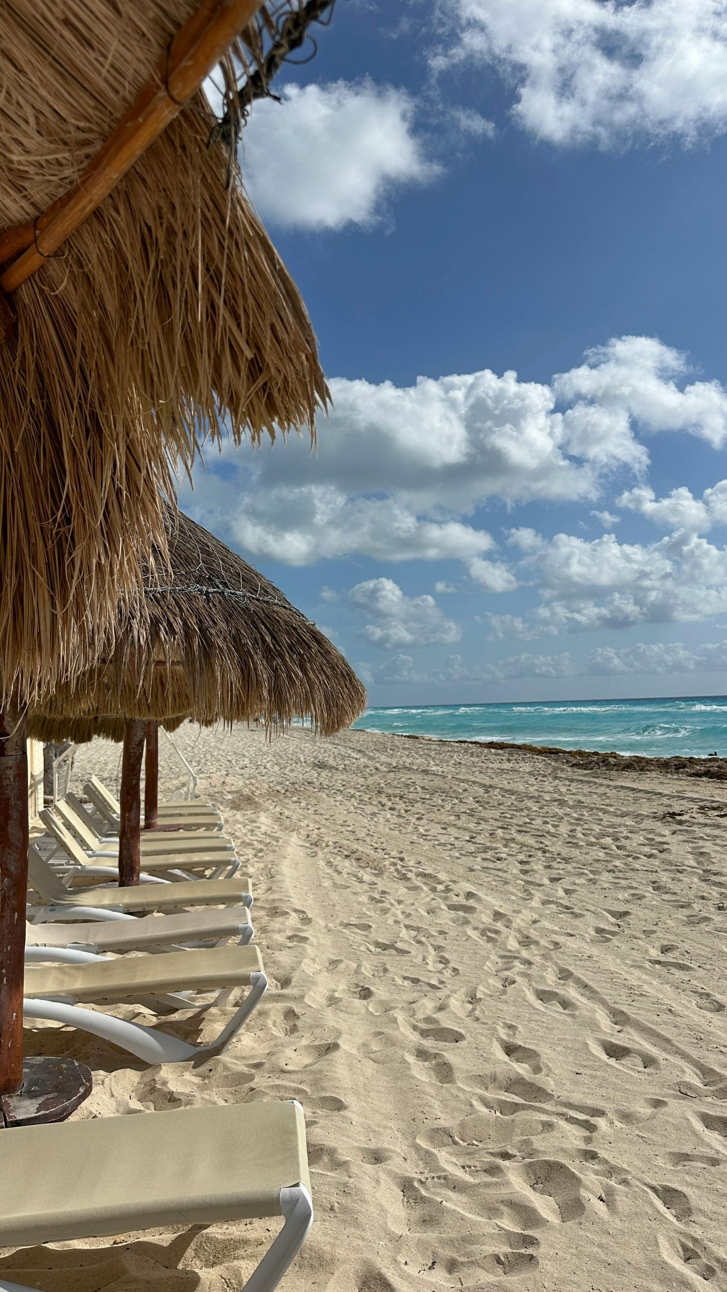 journey Scenic view of sandy beach with thatched umbrellas in Cancún, ideal for relaxation.